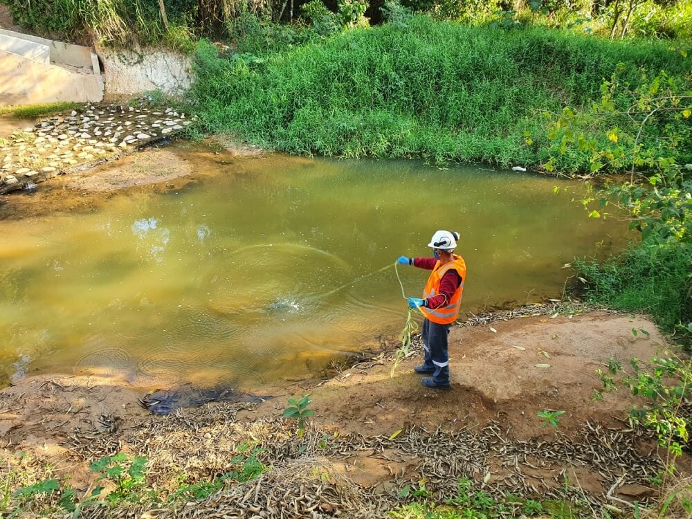 Técnico da Ambsolution Engenharia Ambiental realiza amostragem e monitoramento de água em rio para processos de licenciamento ambiental