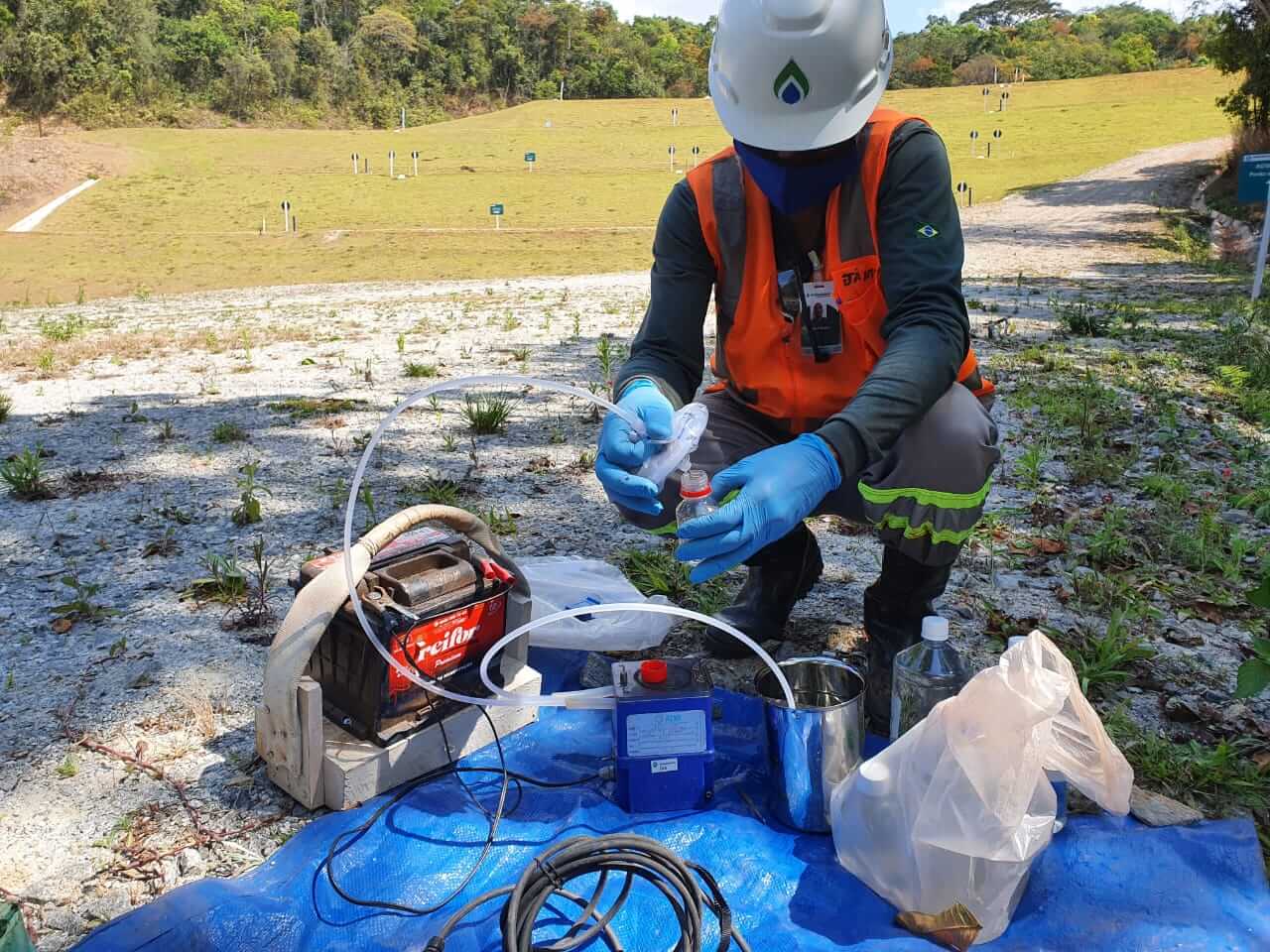 Profissional com EPI da Ambsolution realiza coleta de baixa vazão com bomba peristáltica para amostragem de águas subterrâneas